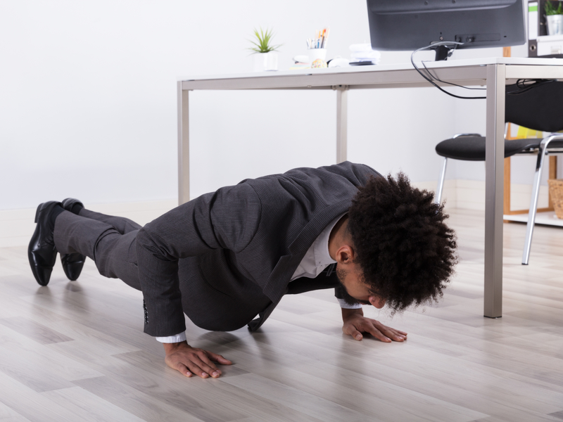 Jeune homme d'affaires fait des push-ups au bureau