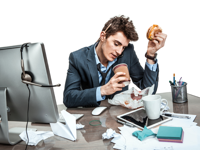 Homme mange à son bureau