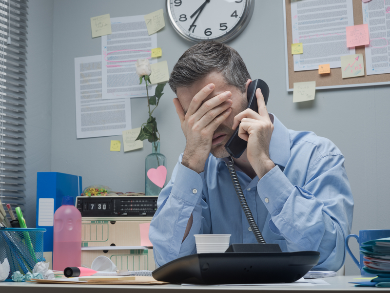 Homme stressé parle au téléphone du bureau