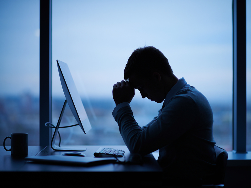 Homme d'affaires fatigué ou stressé assis devant l'ordinateur dans le bureau