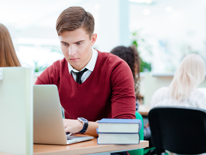 Étudiant travaille sur son ordinateur dans la bibliothèque