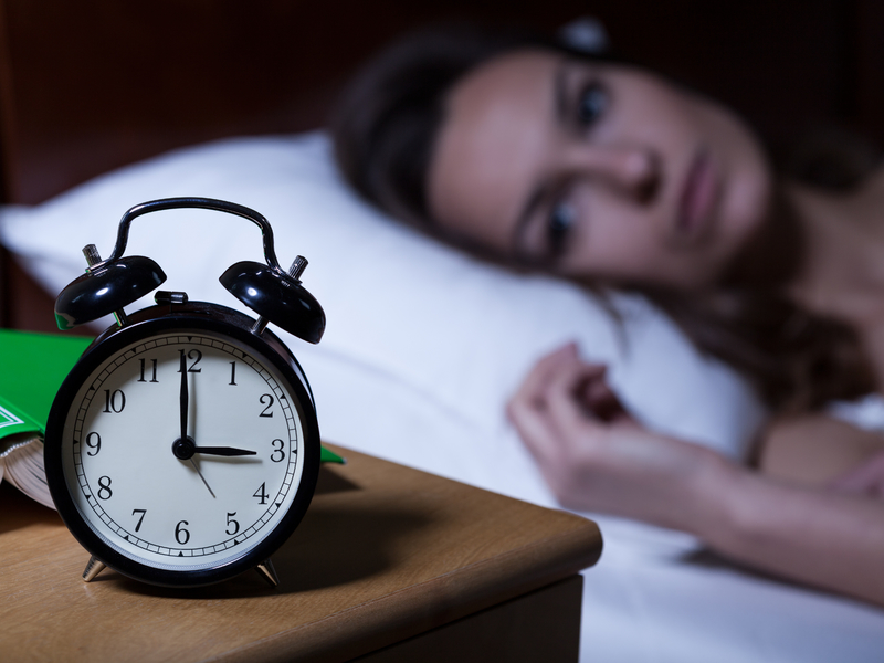 Femme qui ne dort pas avec un horloge à 3h du matin