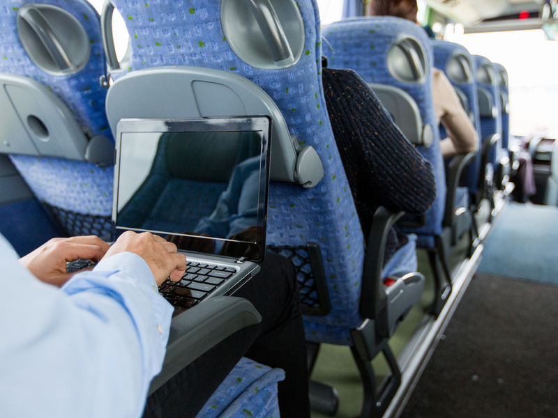 Homme travaille sur son ordinateur assis dans un bus