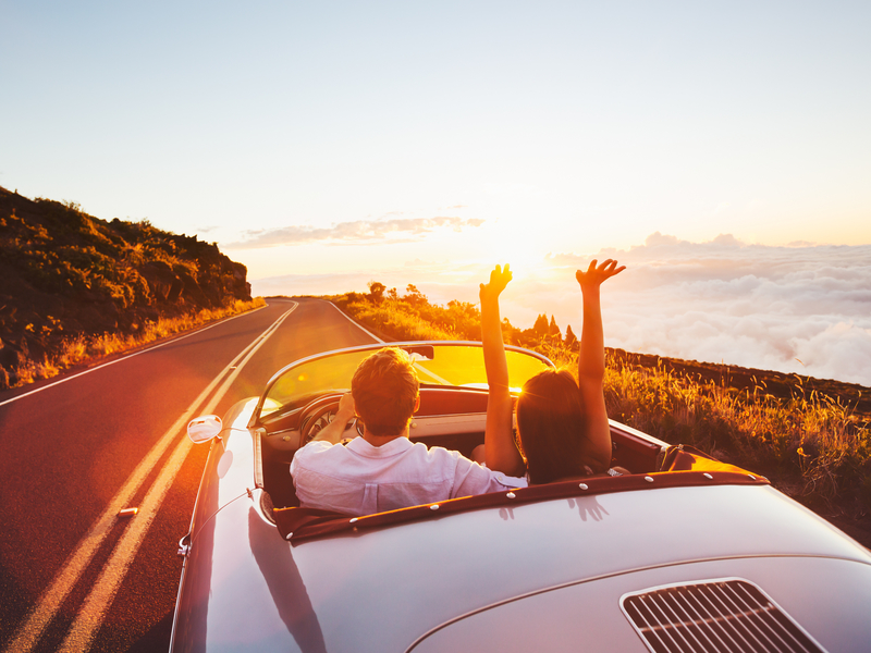 Homme et femme dans une voiture décapotable au soleil