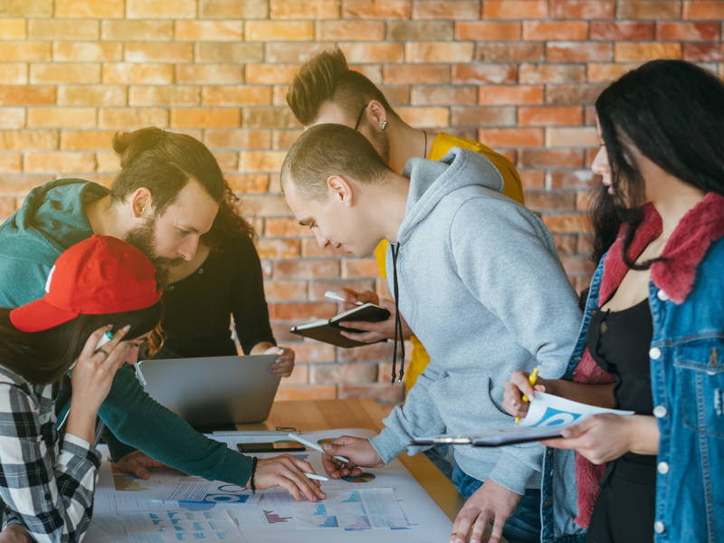 De jeunes travailleurs autour d'une table de travail