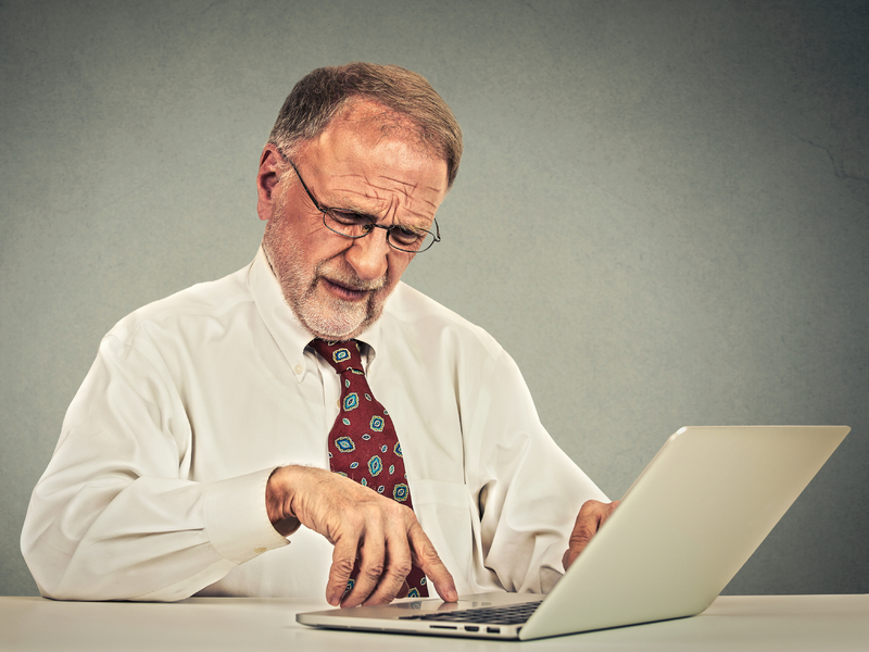 Homme âgé travaille sur ordinateur