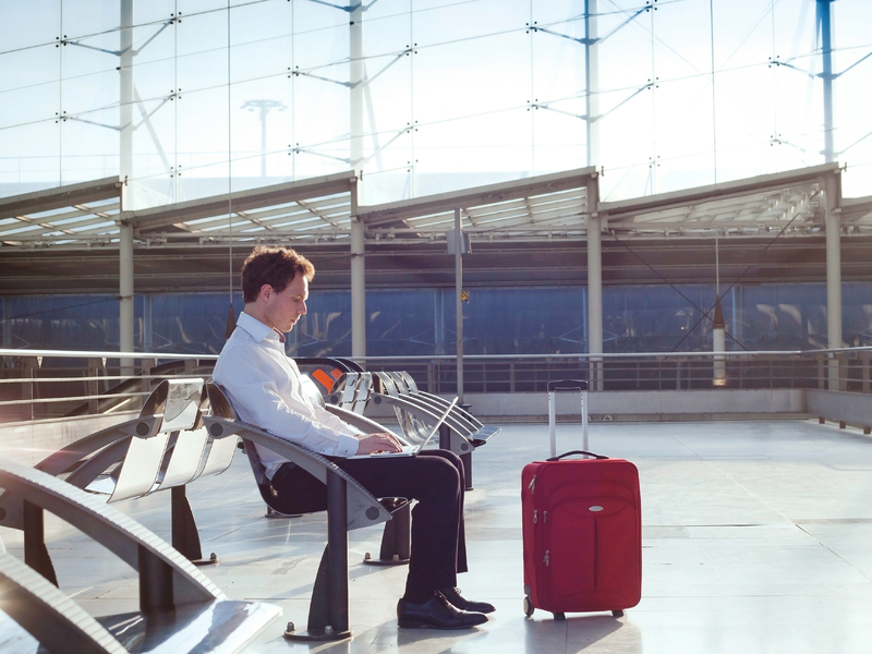 Homme travaille sur son ordinateur portable en attendant son avion dans un aéroport