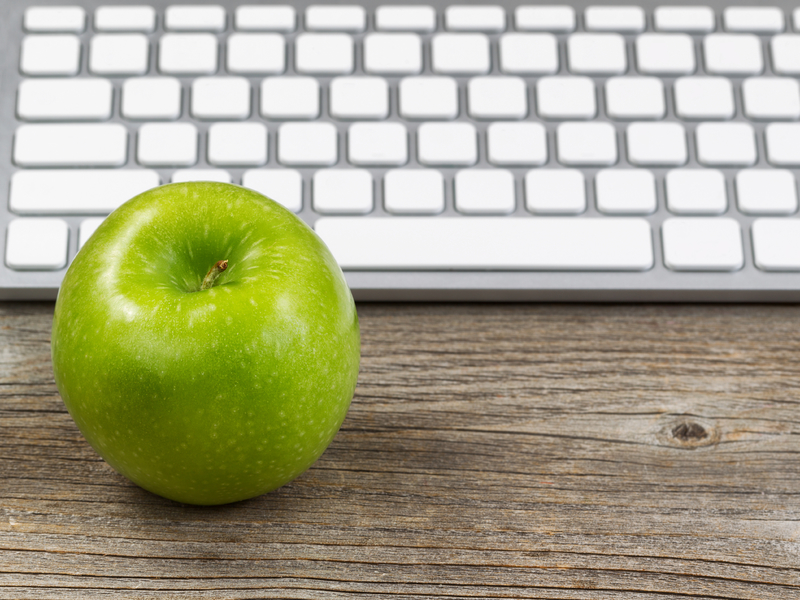 Une pomme devant un clavier d'ordinateur