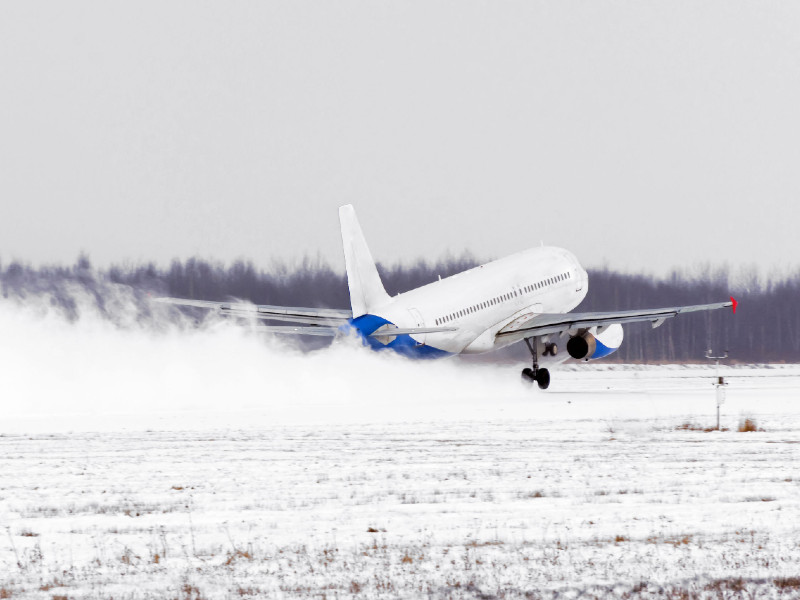 Un avion décolle d'une piste enneigée