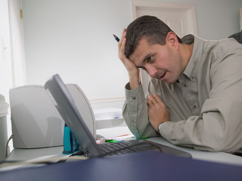 Un employé stressé regarde son ordinateur