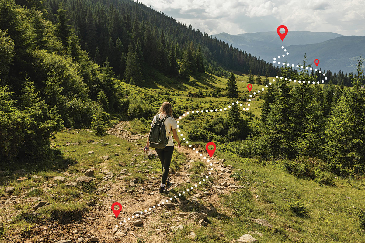 Femme marchant sur un sentier de montagne verdoyant