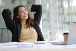Femme souriante se détendant à son bureau